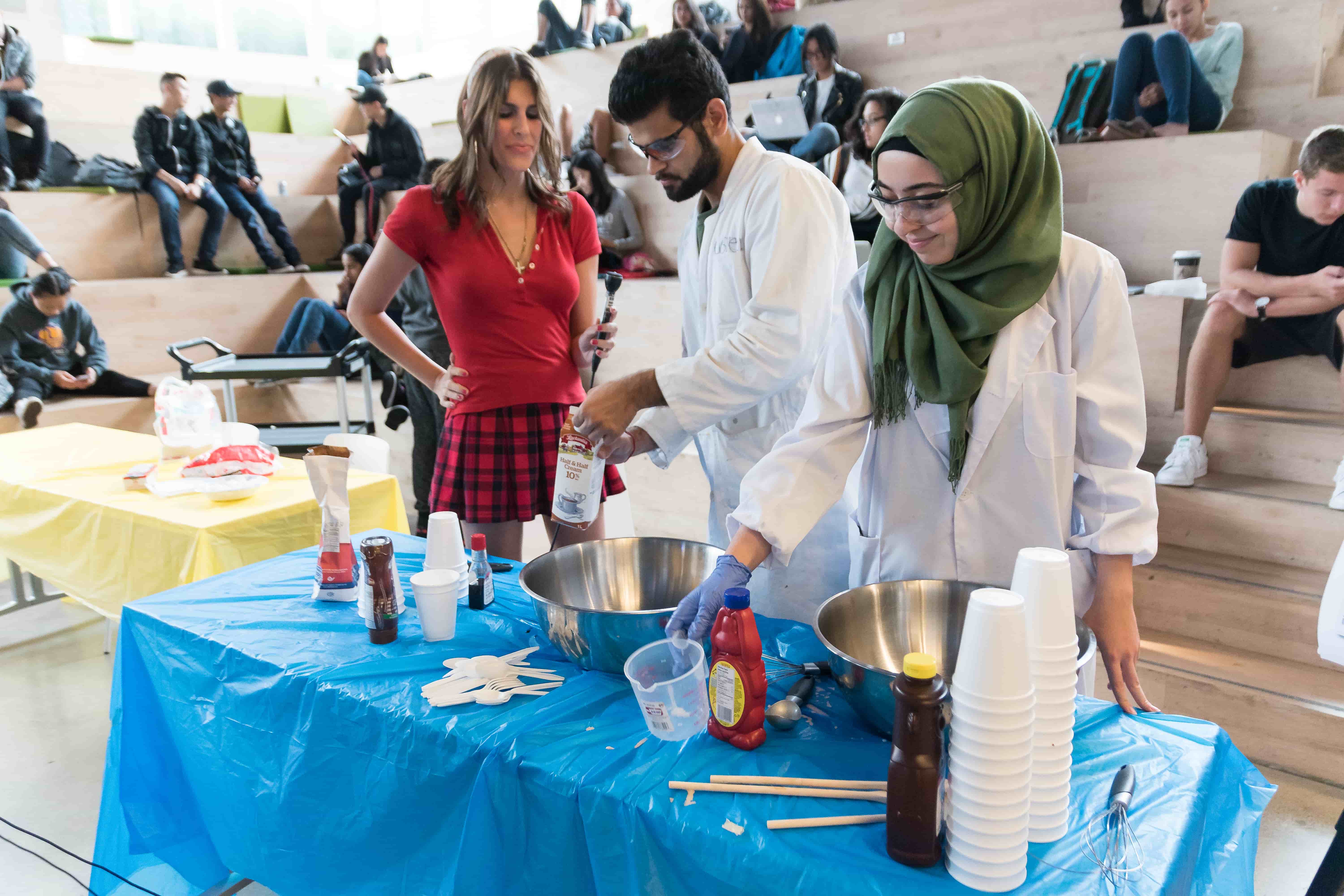 Scientists doing experiments at a table for an audience